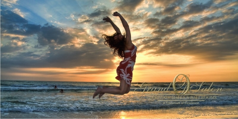 Woman Jumping On Beach At Sunset | Best Wedding Gifts For The Bride And Groom To Give Each Other | Blogs