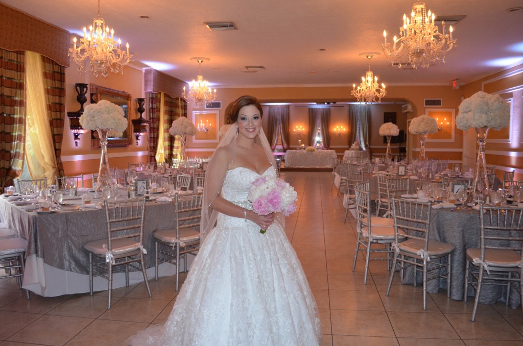 bride in wedding dress with pink and white bouquet in dinning area