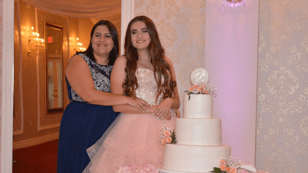 Mother and daughter hugging next to a birthday cake