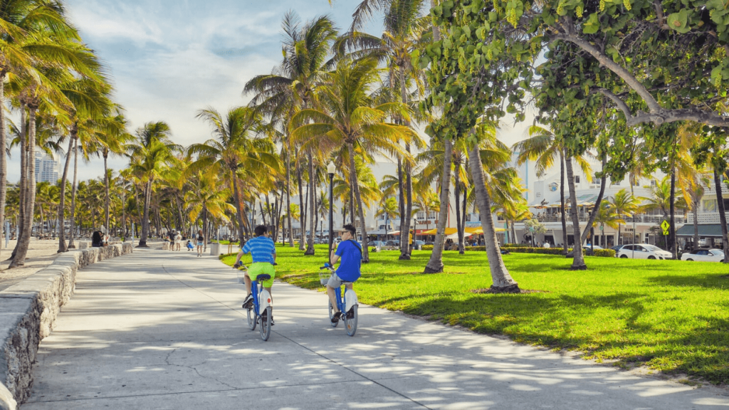 Two boys riding bikes along Ocean Drive in Miami