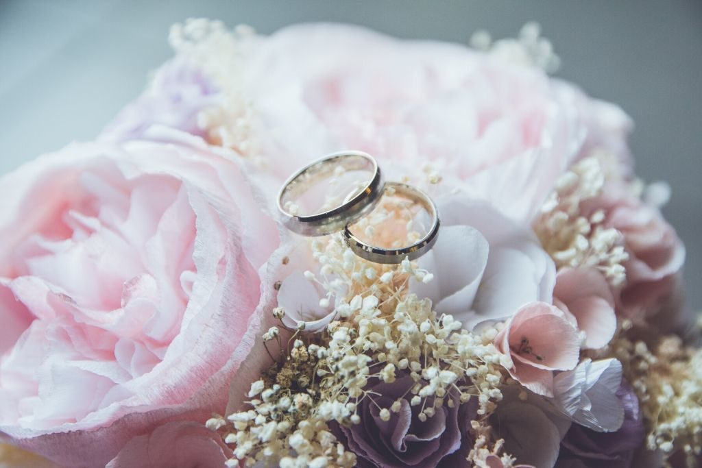 A couple of wedding rings laying on flowers
