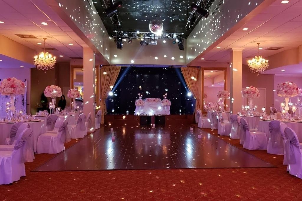An indoor wedding venue with lights, tables, and a dance floor