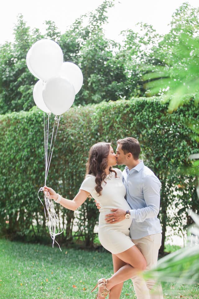 A couple kissing at their baby shower party