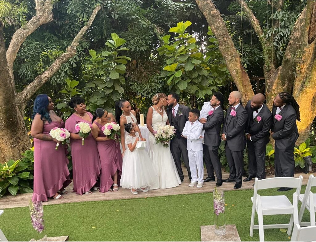 An African American couple called Mr and Mrs Perez on their wedding day surrounded by family